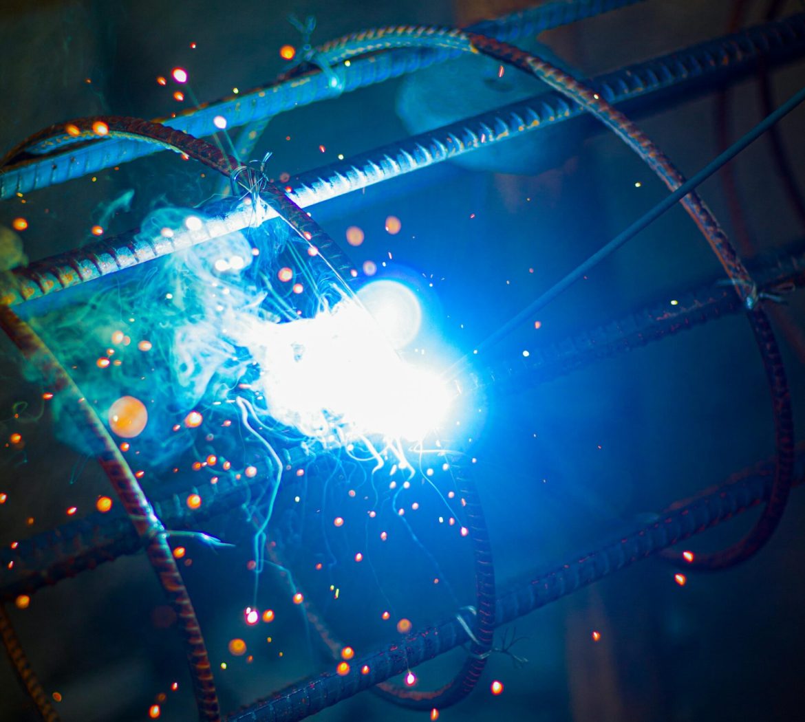Close-up of intense welding sparks flying from a metal frame, showcasing industrial craftsmanship.